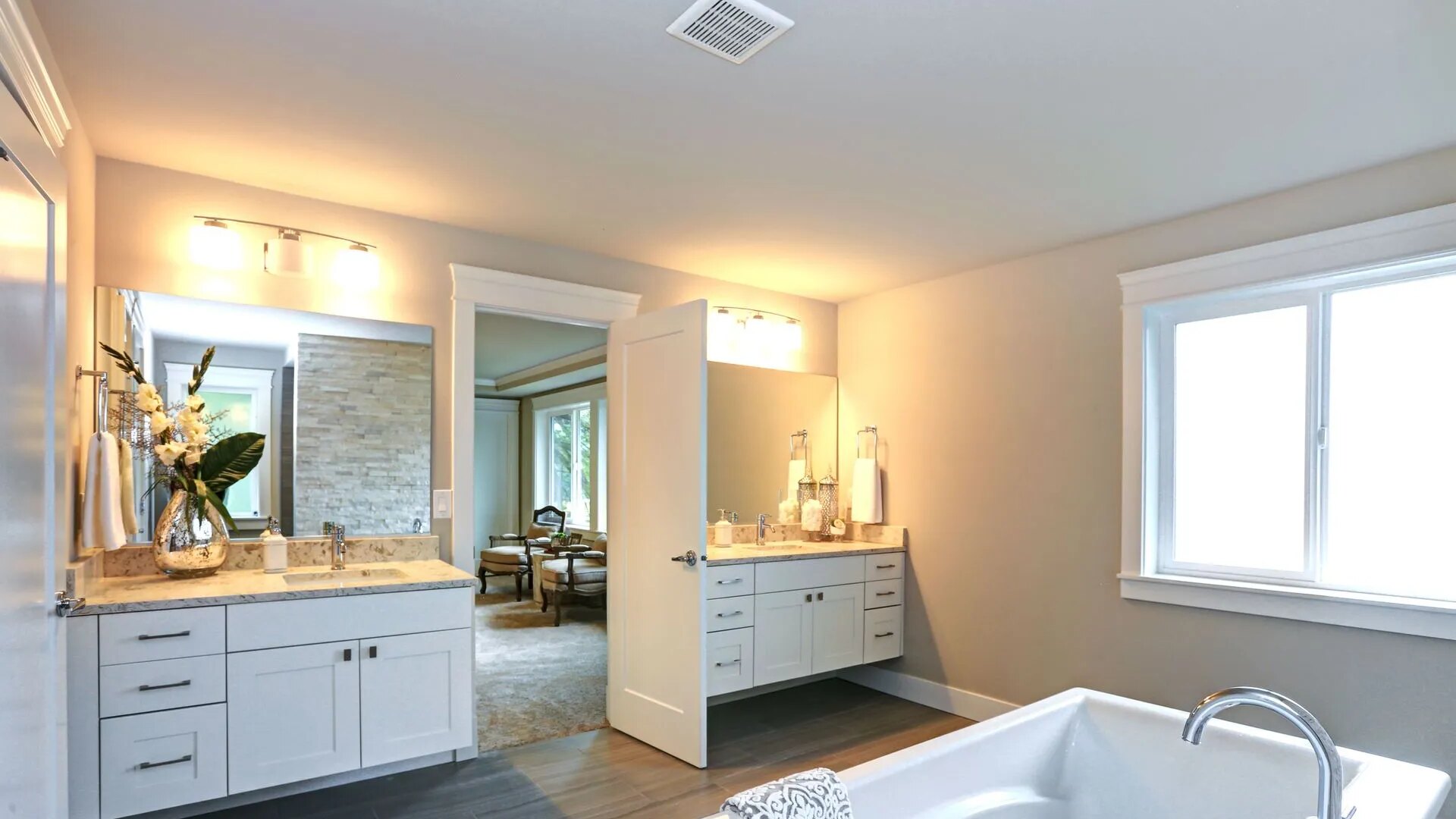 Bathroom with white cabinets and bright lighting